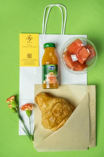 a lunch box with a bottle of orange juice and a pastry at Hotel Tempio Di Pallade in Rome