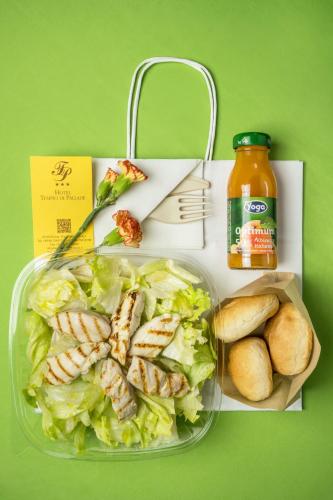 a plastic container filled with a salad with chicken and bread at Hotel Tempio Di Pallade in Rome