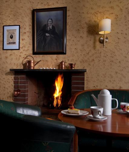 un comedor con chimenea, mesa y chimenea en Sunndalsøra Hotell, en Sunndalsøra