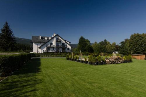 a large house with a large yard with green grass at Samosia in Karpacz