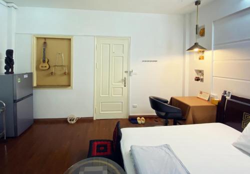 1 dormitorio con cama, escritorio y puerta en Doctor Homestay 2 en Hanoi