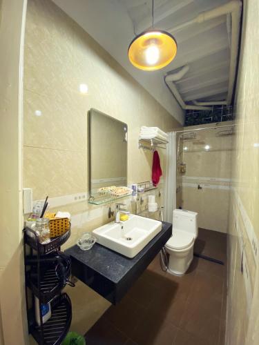 a bathroom with a sink and a toilet and a mirror at Doctor Homestay 2 in Hanoi