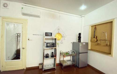 a white room with a refrigerator and a shelf at Lotus Homestay 2 in Hanoi