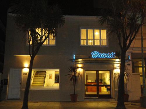 a building with a neon sign in front of a store at Hotel Hawaii in Mar del Plata