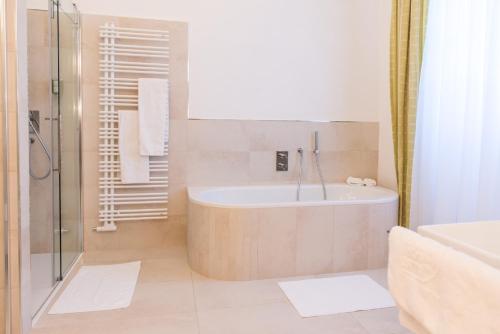 Hotel Kartause في غامينغ: حمام مع حوض استحمام ودش ومغسلة