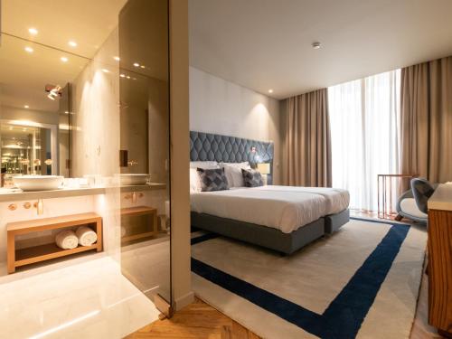 1 dormitorio con 1 cama extragrande y baño en The Wine House Hotel - Quinta da Pacheca en Lamego
