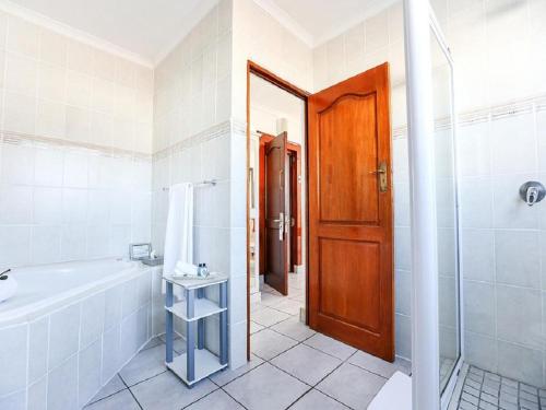 a bathroom with a tub and a shower and a sink at Misty Waves Boutique Hotel in Hermanus