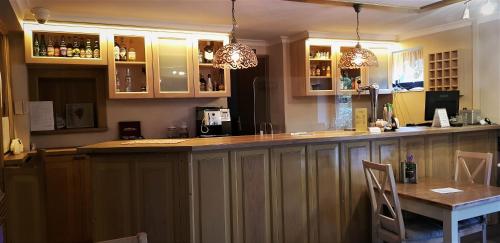 a kitchen with a bar with a table and chairs at Harmonia in Biała Podlaska