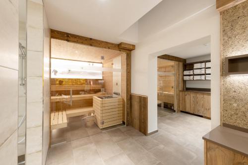 a bathroom with a walk in shower and a sink at tannberg LODGE in Schröcken