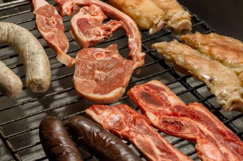 a bunch of meats and sausages on a grill at Hotel Farré D'avall in Barruera