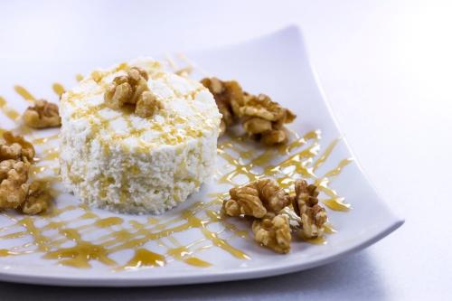 a white plate with a piece of cake and walnuts at Hotel Farré D'avall in Barruera