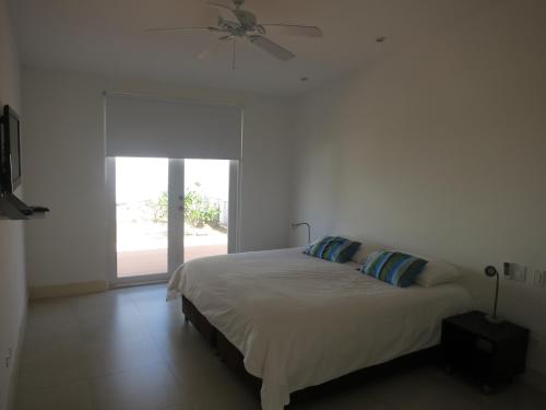um quarto com uma cama, uma ventoinha de tecto e uma janela em Tamarindo em San Andrés
