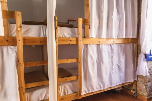 two bunk beds in a room with wooden walls at Ashavana Hostel in El Médano
