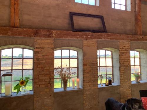 a room with four windows with flowers and candles at Bremsmaj Farm Holiday in Kværs