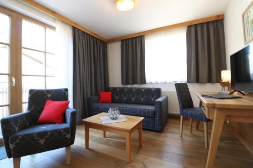 ein Wohnzimmer mit einem Sofa und einem Tisch in der Unterkunft Hotel Bräu in Rauris