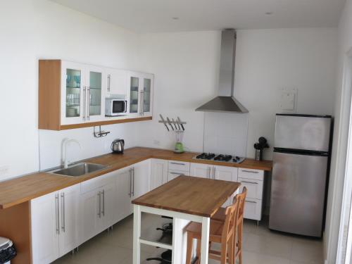 a kitchen with white cabinets and a stainless steel refrigerator at Tamarindo in San Andrés
