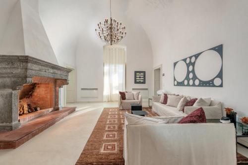 ein Wohnzimmer mit einem Sofa und einem Kamin in der Unterkunft Villa Torre Bianca by Emily Hotels in Polignano a Mare