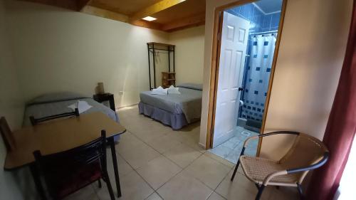 a room with a bed and a table and a room with a bedroom at La Tribu del Indio, Desayuno Incluido in San Pedro de Atacama