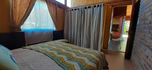 a bedroom with a bed and a window at Casa Amanecer Vichuquén in Lago Vichuquen