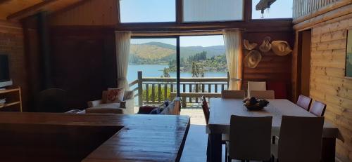 a dining room with a table and a view of a lake at Casa Amanecer Vichuquén in Lago Vichuquen