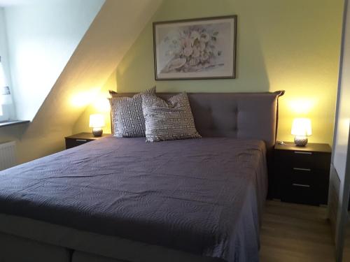 - une chambre avec un lit violet et deux lampes dans l'établissement Ferienwohnung Sabine, à Coblence