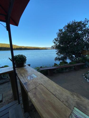 a picnic table with a view of a lake at Casa Amanecer Vichuquén in Lago Vichuquen