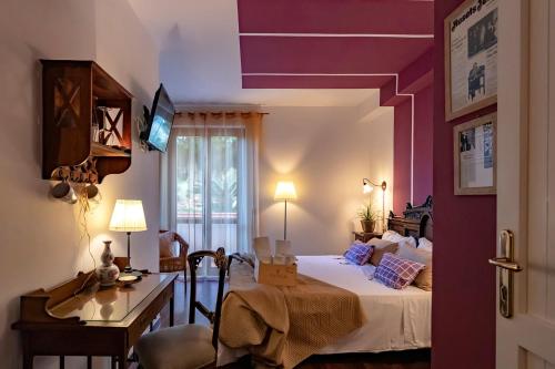 a hotel room with a bed and a desk and a desk at Hotel Pocho in San Vito lo Capo