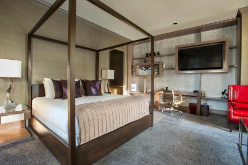 a bedroom with a canopy bed and a red chair at Fairmont Chicago Millennium Park in Chicago