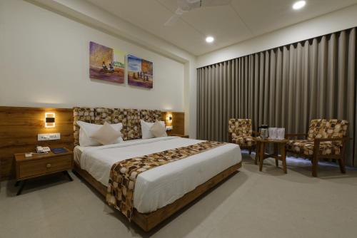 a hotel room with a bed and a table and chairs at HOTEL FLOURISH INTERNATIONAL in Ahmedabad
