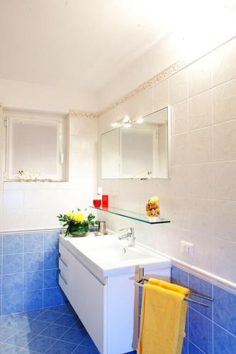 a blue and white bathroom with a sink and a mirror at Tremezzo Residence 3-1 of 11 apartments in an exclusive residence by Italian Apartments in Tremezzo