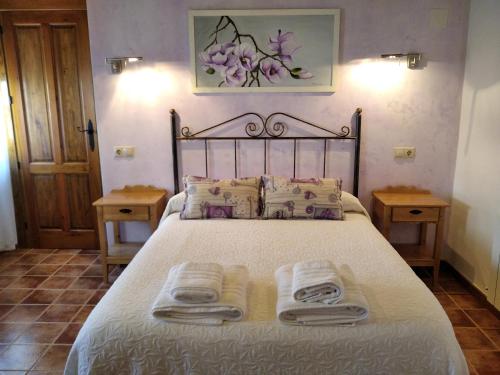 ein Schlafzimmer mit einem Bett mit zwei Handtüchern darauf in der Unterkunft Apartamentos El Callejón in Riópar