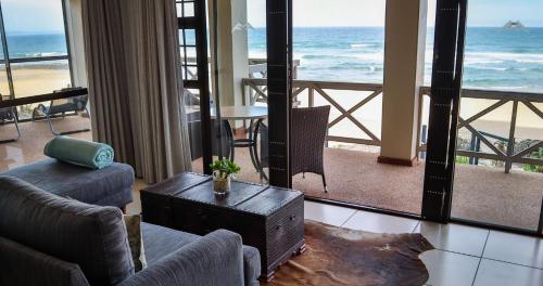 a living room with a view of the ocean at On the Beach Guesthouse Jeffreys Bay in Jeffreys Bay