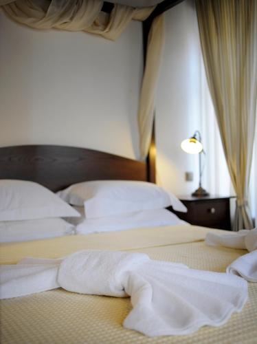 a bedroom with two beds with white sheets and a window at Marelia Hotel in Poligiros