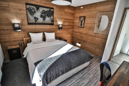 サン・ジャン・ド・シックスにあるAppt Primevères - Centre village, Vue montagne - AravisTourの木製の壁のベッドルーム1室(大型ベッド1台付)