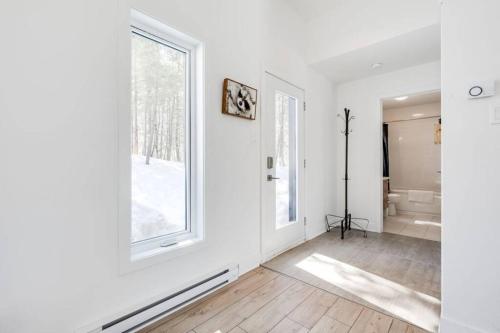 a white room with a bathroom with a tub and a window at Chalet le Raton in Chertsey