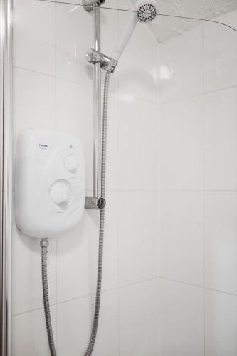 a shower with a shower head in a bathroom at Pendicke Cottage, Southam in Southam
