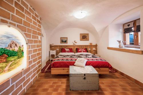 una camera con letto e muro di mattoni di Appartamento Mariagrazia a Tesero