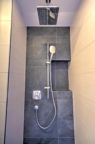 a bathroom with a shower with a shower head at Der Siegeler B&B - this lifestylehotel rocks in Mayrhofen