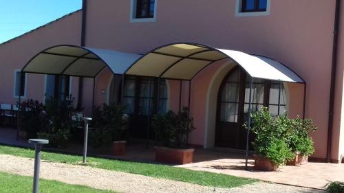 un edificio púrpura con dos arcos a un lado en Il Cuoricino Podere le Bozze con piscina, WI-FI, posto auto, en Castagneto Carducci