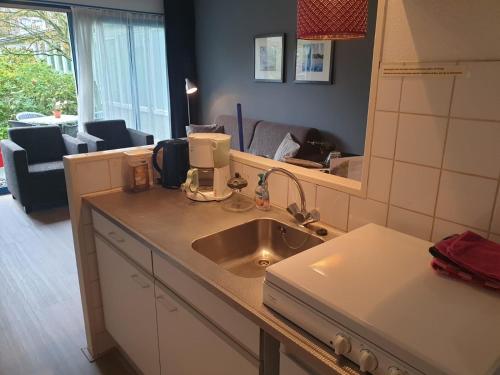 a kitchen counter with a sink and a mirror at Nova Zembla in Hollum