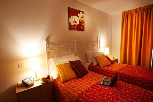 a bedroom with two beds and a laptop on the bed at Tremezzo Residence 3-1 of 11 apartments in an exclusive residence by Italian Apartments in Tremezzo