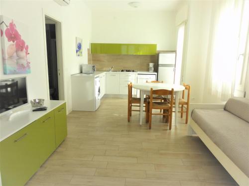 una cucina e una sala da pranzo con tavolo e divano di Villa Dogi Sud 20 a Bibione