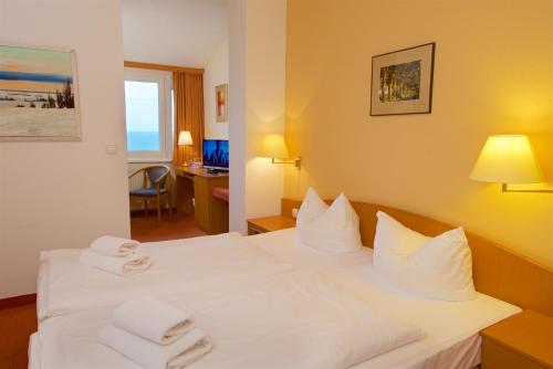 a hotel room with a bed with towels on it at Panorama Hotel Lohme in Lohme