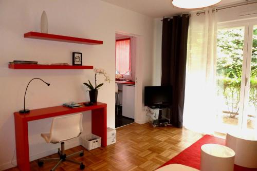 a living room with a red desk and a television at Appartement Monplaisir Part Dieu in Lyon