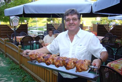 a man holding a tray of food on a stick at Gasthof und Pension Haunschmid in Rechberg