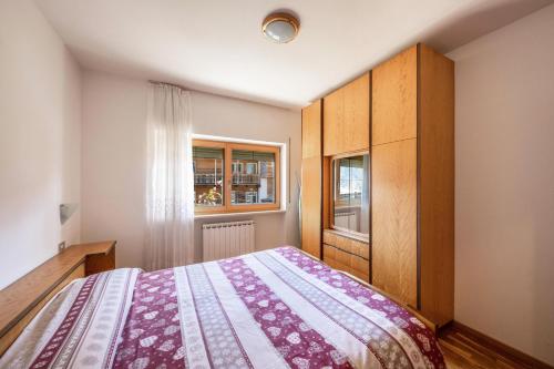 Schlafzimmer mit einem Bett und einem Fenster in der Unterkunft Villa Mazzel - Cima 12 in Vigo di Fassa