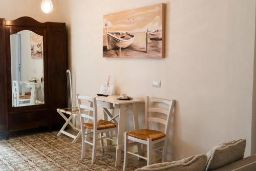 a room with a table and chairs and a mirror at Antico Mondo Rooms & Suites in Polignano a Mare