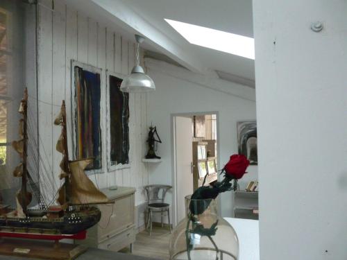 a living room with a table and chairs and a room with a ceiling at gites Les Lebes - Grange loft in Sempesserre