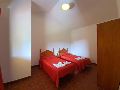 two beds in a room with red sheets at Casas Rurales Amparo Las Hayas in Valle Gran Rey