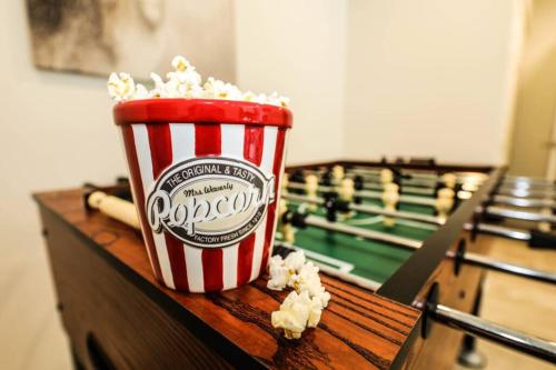 a cup of popcorn sitting on top of a table next to a billiard at La Loutre in Chertsey